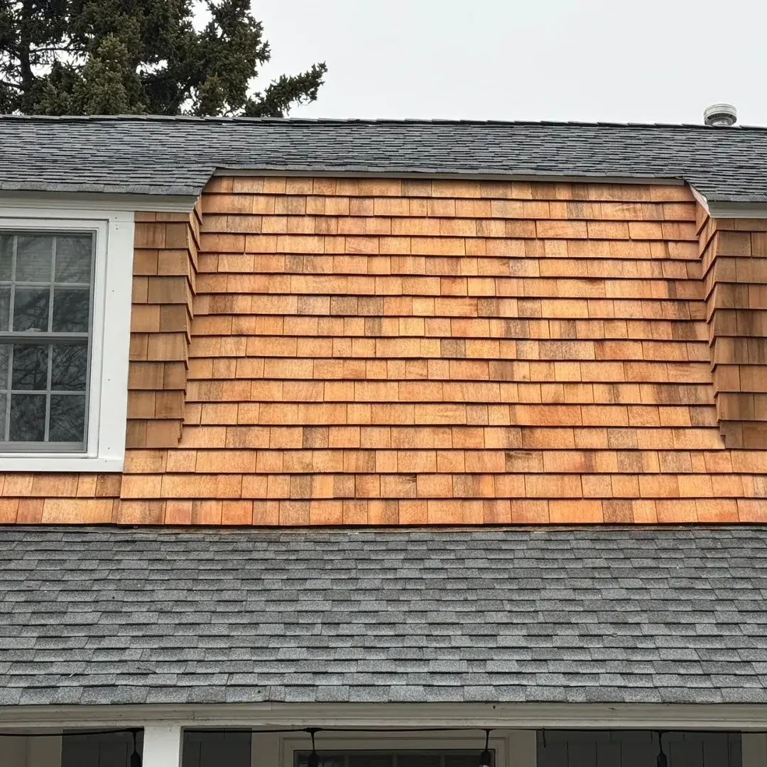 Close-up of freshly installed cedar shingles on a dormer.