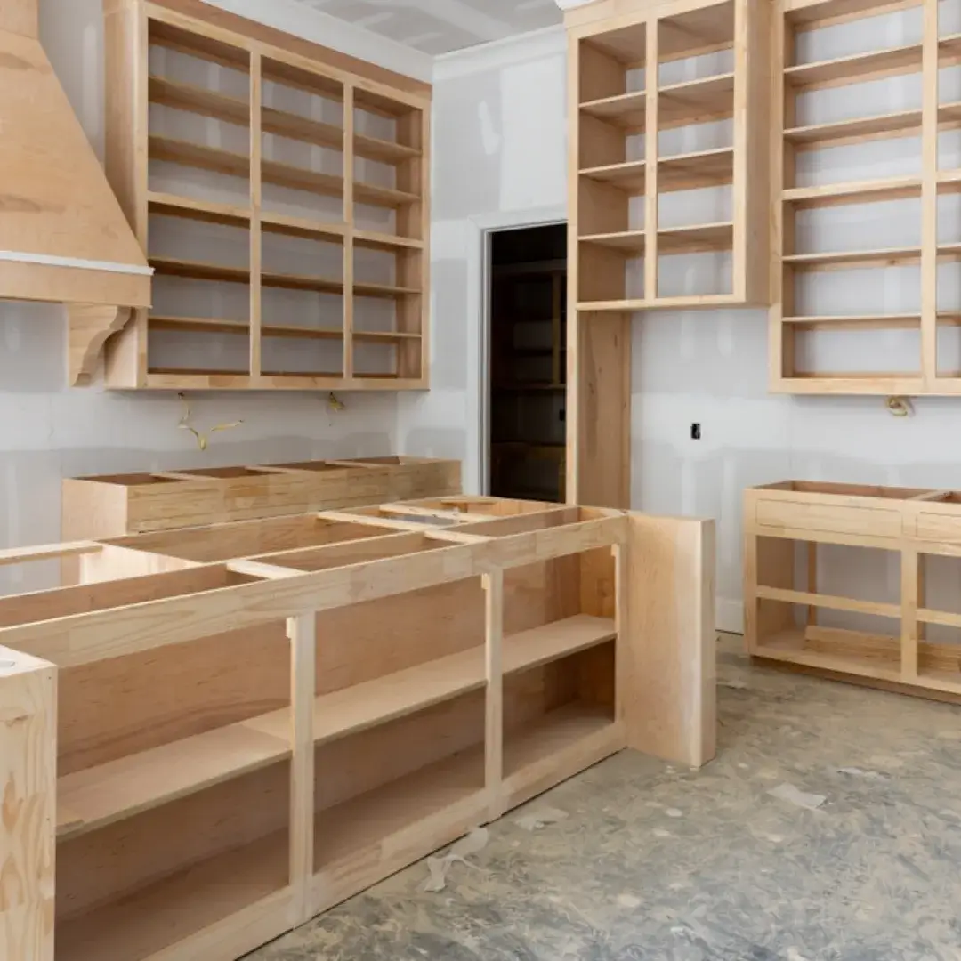 Unfinished wooden kitchen cabinets being installed in a new home construction.