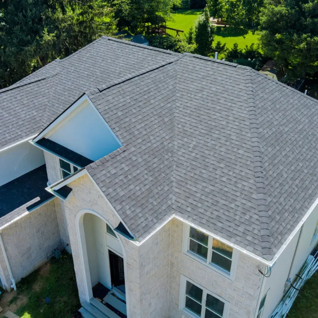 A roof under repair with exposed plywood sheathing and old shingles being removed.