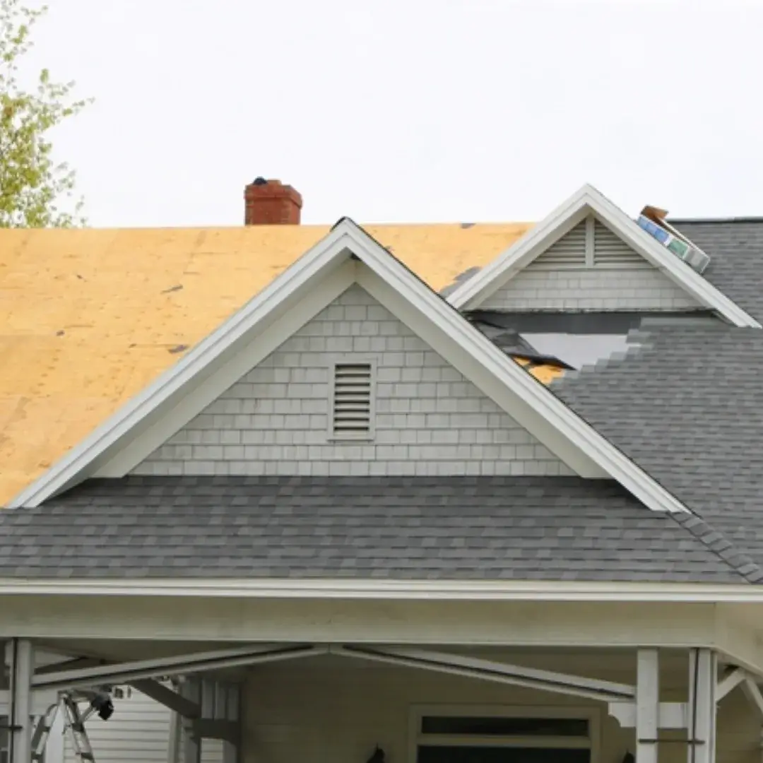 Aerial view of a modern home with a gray asphalt shingle roof and stone exterior.