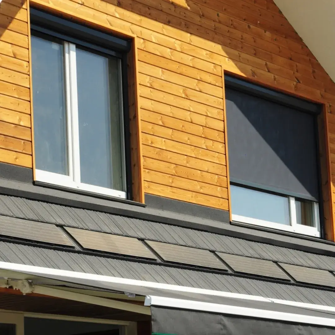 Large sliding windows on a modern home with a wooden facade and dark exterior accents.